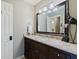 A bathroom with a vanity with a granite countertop and dark brown cabinets at 4185 Etcetera Ln, Cumming, GA 30041