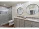 Bathroom featuring a walk-in shower, wood-look walls, dual sinks, and granite countertops at 4185 Etcetera Ln, Cumming, GA 30041