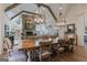 Elegant dining room with exposed wood beams, stone fireplace, wood floors, and decorative lighting at 4185 Etcetera Ln, Cumming, GA 30041