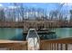 View of the boat dock with a boat lift and stairway access to a wooded lot on the waterfront at 4185 Etcetera Ln, Cumming, GA 30041