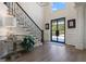 Bright foyer with hardwood floors, staircase, black iron railing, and black framed front door at 4185 Etcetera Ln, Cumming, GA 30041