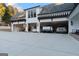 View of a three-car garage featuring cars, motorcycles, and a concrete driveway at 4185 Etcetera Ln, Cumming, GA 30041