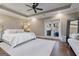 Bright main bedroom with tray ceiling, ceiling fan, french doors, and a cozy sitting area at 4185 Etcetera Ln, Cumming, GA 30041