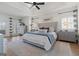 Bright main bedroom with a ceiling fan, tray ceiling, detailed trim, and ensuite bath at 4185 Etcetera Ln, Cumming, GA 30041