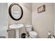 Half bathroom with a pedestal sink, toilet, decorative mirror, and modern fixtures at 4439 Persian Ct, Snellville, GA 30039