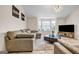 Inviting living room featuring a sectional sofa, a modern light fixture, and a bay window at 4439 Persian Ct, Snellville, GA 30039