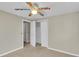 Bright bedroom featuring neutral carpet, ceiling fan, and closet with sliding doors at 6198 Rocky Creek Dr, Douglasville, GA 30135