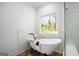 Bright bathroom featuring a freestanding tub and window with a wooded view at 5167 Martin St, Covington, GA 30014