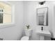 Stylish powder room featuring a pedestal sink, modern fixtures, and natural light at 5167 Martin St, Covington, GA 30014