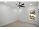Bright bedroom with neutral carpet, a ceiling fan, and a window with a view at 5167 Martin St, Covington, GA 30014