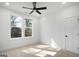 Bright bedroom featuring neutral carpet, a modern ceiling fan, and double windows offering natural light at 5167 Martin St, Covington, GA 30014