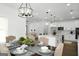 Open-concept dining area flows into a modern kitchen with white cabinets, granite countertops, and stainless steel appliances at 5167 Martin St, Covington, GA 30014