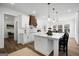 Stylish kitchen boasts white cabinets, a granite island, and open access to the dining space at 5167 Martin St, Covington, GA 30014