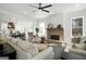 Bright and airy living room with a fireplace, ceiling fan, and open concept to the kitchen at 5167 Martin St, Covington, GA 30014