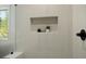 Elegant shower with white tile, a built-in niche with mosaic tile, and glass door at 5167 Martin St, Covington, GA 30014