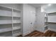 Bright walk-in closet featuring custom white shelving and hanging rods with wood-look flooring at 5167 Martin St, Covington, GA 30014
