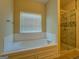 Bright bathroom featuring a soaking tub with tiled surround and a walk-in shower at 1186 Diamond Xing, Mcdonough, GA 30252