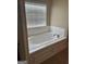 Bright bathroom featuring a soaking tub with white tile surround and chrome fixtures at 1186 Diamond Xing, Mcdonough, GA 30252