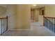 Carpeted upper-level hallway with wrought iron railing offering access to bedrooms and other areas at 1186 Diamond Xing, Mcdonough, GA 30252