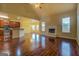 Open-concept living room with hardwood floors, fireplace, and kitchen view at 1186 Diamond Xing, Mcdonough, GA 30252