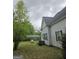 A view of the backyard, showcasing a covered parking area and propane tank, surrounded by lush greenery at 2171 Highway 42 S, Mcdonough, GA 30253