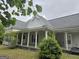 Exterior showing a classic home's front porch and side with green foliage under a grey sky at 2171 Highway 42 S, Mcdonough, GA 30253