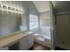 Bright bathroom showcasing large vanity and tub with tiled enclosure at 10988 Mansura Pl, Hampton, GA 30228