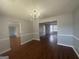 Dining room with elegant chandelier and wood-look floors leading to adjacent rooms at 10988 Mansura Pl, Hampton, GA 30228