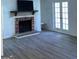 Bright living room with a cozy brick fireplace, a TV mounted above the mantel, and a door to the outside at 2978 Parc Lorraine # Building 4, Lithonia, GA 30038