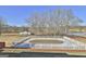 Pool area ready for opening with a pool cover, a fenced surround, with lawn and outbuildings in the background at 312 Hampton Rd, Fayetteville, GA 30215