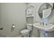 Simple half bath with white fixtures, cabinet, and a large round mirror at 312 Hampton Rd, Fayetteville, GA 30215