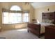 Bright bedroom featuring a built-in window seat, large arched window, and classic wood furnishings at 300 Legacy Ln, Peachtree City, GA 30269