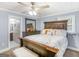 Charming bedroom featuring a wooden bed frame, dresser with mirror, and a ceiling fan with light fixture at 1202 Coan Dr, Locust Grove, GA 30248