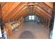 Bright attic featuring exposed beams, storage shelves, and natural light from a window at 195 Twin Oaks Dr, Hampton, GA 30228