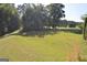 Backyard view features a wide expanse of manicured lawn and mature trees at 195 Twin Oaks Dr, Hampton, GA 30228