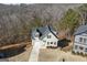 Aerial shot of a charming light green house with a long driveway and a beautiful wooded backdrop at 3185 Tackett Rd, Douglasville, GA 30135