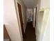 Long hallway with multiple doors showcasing an older heater and carpet flooring at 439 Oakside Sw Dr, Atlanta, GA 30331