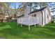 Backyard with a white wood deck and green lawn surrounded by trees at 9317 Thomas Rd, Jonesboro, GA 30238