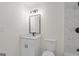 Modern bathroom features marble tiling, a toilet, and a single sink vanity at 9317 Thomas Rd, Jonesboro, GA 30238