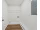 Bright laundry room with wood-look floors, wire shelving, and utility connections at 9317 Thomas Rd, Jonesboro, GA 30238