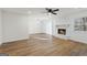 Bright living room with wood floors, stone fireplace, modern ceiling fan, and sliding glass doors at 9317 Thomas Rd, Jonesboro, GA 30238