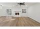 Spacious living room featuring a stone fireplace, modern ceiling fan, and wood flooring at 9317 Thomas Rd, Jonesboro, GA 30238