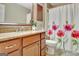 Well-lit bathroom featuring a wooden vanity, granite countertop, and floral shower curtain at 123 Fielding Rdg, Peachtree City, GA 30269