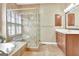 Bathroom featuring a glass-enclosed shower, soaking tub, vanity with wooden cabinets, and a tile floor at 123 Fielding Rdg, Peachtree City, GA 30269