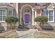 Inviting entrance with a charming purple door, enhanced by a welcoming wreath and manicured bushes at 123 Fielding Rdg, Peachtree City, GA 30269