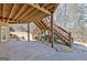 Outdoor patio area beneath a wooden deck with stairs surrounded by landscaped stones and trees at 123 Fielding Rdg, Peachtree City, GA 30269