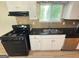 Well-lit kitchen with black appliances, laminate countertops, and white cabinetry at 3859 Rosedale Ln, Douglasville, GA 30135
