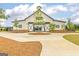 Exterior of community center featuring barn-style architecture, gated entryway, and mature trees at 1653 Sungrown Way, Mcdonough, GA 30253