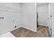 Well-lit laundry room featuring vinyl flooring, a wire shelf, and access to storage or utility space at 1653 Sungrown Way, Mcdonough, GA 30253