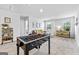 Bright living room featuring a foosball table, gray sofa, and a workspace near the window at 1653 Sungrown Way, Mcdonough, GA 30253